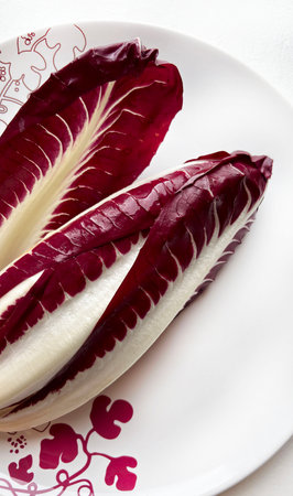 Red radicchio, a Treviso variety on a plate. It's a chicory with long, deep red leaves and white veins. Healthy and vegetarian food. Italian cuisine.の写真素材