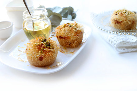 Kataifi, a typical Greek and Middle Eastern pastry specialty drizzled with honey and decorated with...