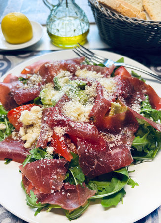 Delicious fresh bresaola with rocket salad and parmesan cheese. Healthy food concept. Italian food....