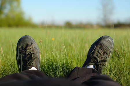A person relaxing lengthened in a meadow on a sunny day.の写真素材