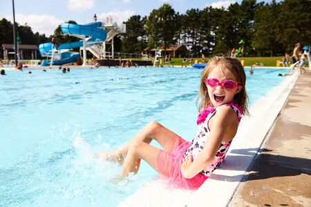 Excited little girl screaming sitting on pool edge