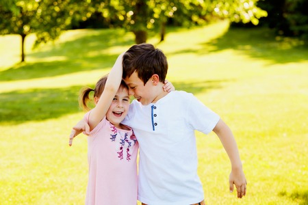 Happy little siblings embracing and laughing