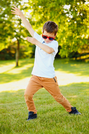Energetic boy in sunglasses dancing in summerの写真素材