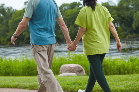 Rear view of young couple walking holding handsの写真素材