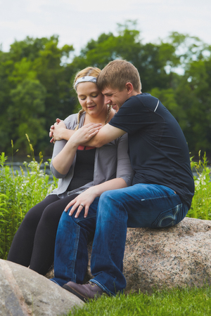 Smiling man embracing his girlfriend keeping warmの写真素材
