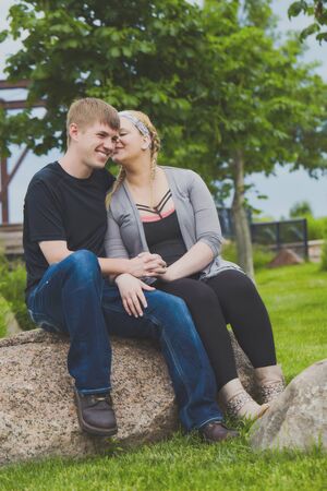 Smiling young girl whispering in ear of manの写真素材
