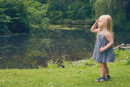 Portrait of serious little girl walking at riverの写真素材