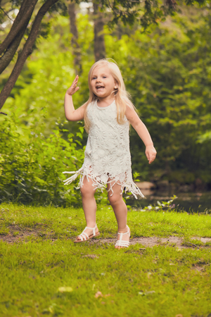 Portrait of happy little girl in summer forestの写真素材