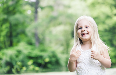 Portrait of cheerful little girl in white dressの写真素材
