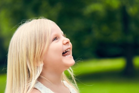 Funny little girl looking up and smilingの写真素材