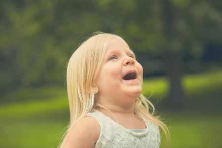 Portrait of surprised little girl in white dressの写真素材