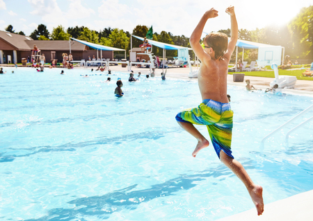Boy jumping in swimming poolの写真素材