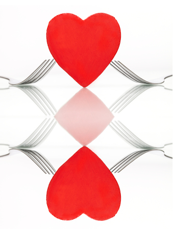Collage of two images: heart with forks on table. Dinner. Valentines day conceptの写真素材