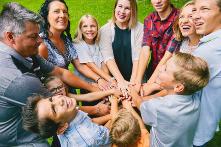 Happy family with nine children heaping handsの写真素材