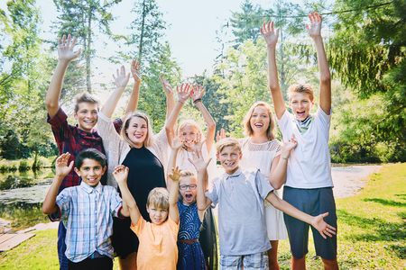 Happy brothers and sisters or friends raising armsの写真素材