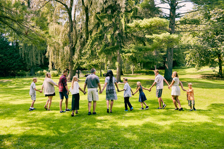 Rear view of happy family of eleven walkingの写真素材