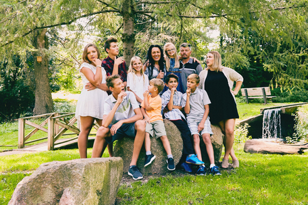 Happy family sitting on stones and communicatingの写真素材