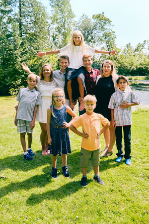 Happy siblings holding sister on their shouldersの写真素材