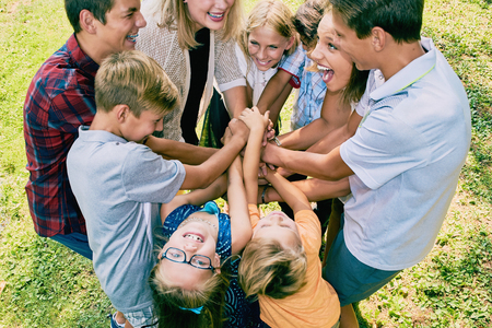 Excited children team heaping hands in summerの写真素材