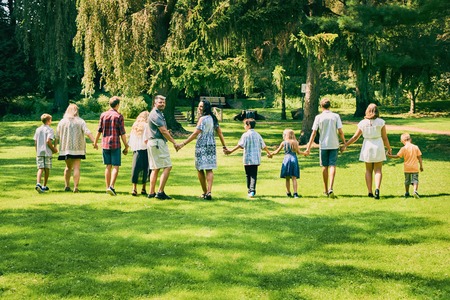 Rear view of happy couple walking with childrenの写真素材