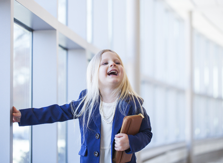 Portrait of funny little girl wearing blue jacket and necklaceの写真素材