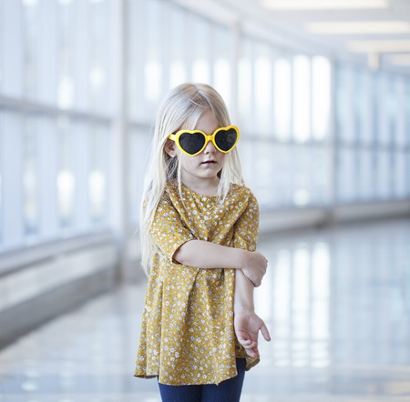 Portrait of cute little girl wearing heart-shaped sunglassesの写真素材