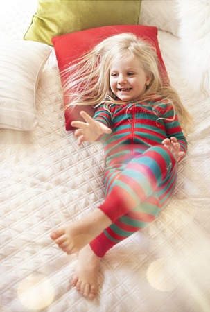 Little girl waking up in morning. Christmas timeの写真素材