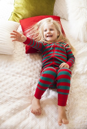 Little girl waking up in morning. Christmas timeの写真素材