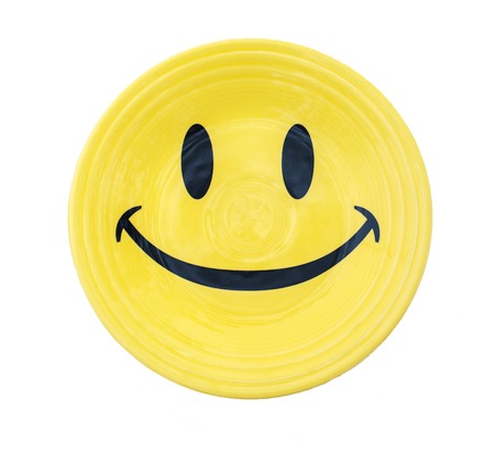 Yellow plate with smile on white backgroundの写真素材