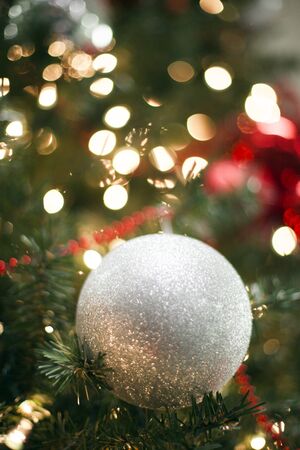 Close-up of glittering bauble on Christmas tree. Christmas ornament with lights. New Year decoration, holiday, celebration, partyの写真素材