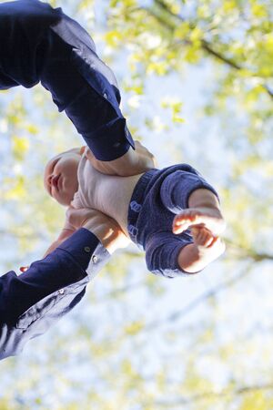 Hands of father holding baby boy. Male hands tossing little child. Childhood and fatherhood concept