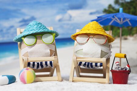 Easter eggs with faces mask at beach. Travel concept. Protection from corona virusの写真素材