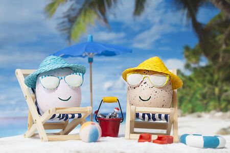 Easter eggs with happy faces at beach. Travel concept.の写真素材