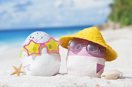 Easter eggs with faces mask at beach. Travel concept. Protection from corona virusの写真素材
