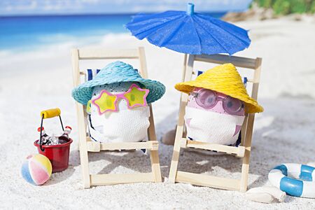 Easter eggs with faces mask at beach. Travel concept. Protection from corona virusの写真素材