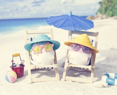 Easter eggs with faces mask at beach. Travel concept. Protection from corona virusの写真素材