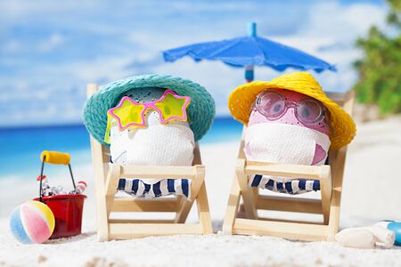 Easter eggs with faces mask at beach. Travel concept. Protection from corona virusの写真素材