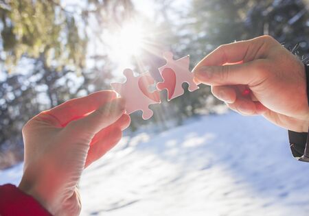 Hands of couple holding puzzles with red heart together. Love conceptの写真素材
