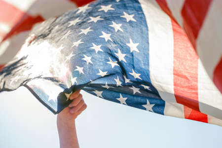 Male hand holding American flag on 4th of July. Independence dayの写真素材
