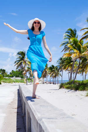 Happy woman with hat walking on the islandの写真素材