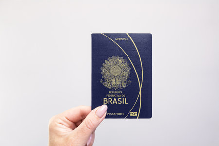 Close-up of a Brazil held passport in hand against a plain white background. Astana, Kazakhstan, 26 October 2024の写真素材