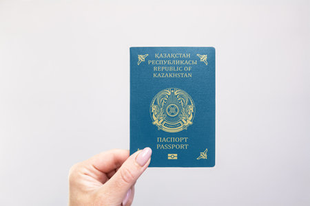 Close-up of a Kazakhstan held passport in hand against a plain white background. Astana, Kazakhstan, 26 October 2024の写真素材