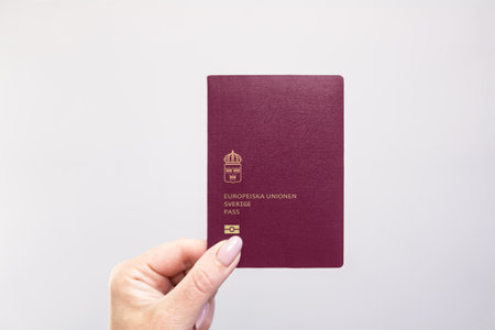 Close-up of a Sweden held passport in hand against a plain white background. Astana, Kazakhstan, 26...