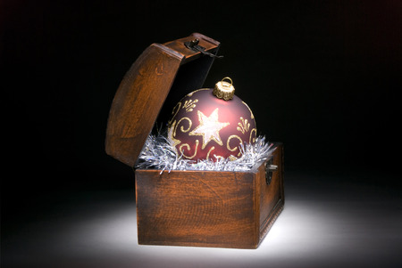 Red decorative sphere (in a casket) on a dark art background.の写真素材