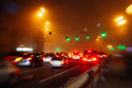 Busy traffic in city fog blur lights of cars on roadの写真素材