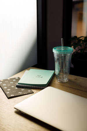 A workplace for creative person with notebook paper and mug with water