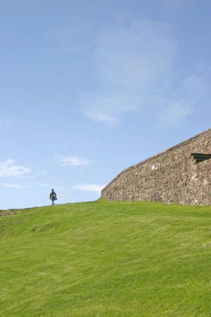 Woman Walking on Grass Bank Stirling Castle in Scotland UKの写真素材