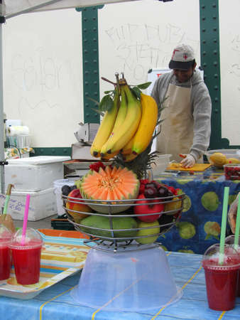 LONDON - AUGUST 15: Unidentified man at a fruit juice stall at Brick Lane Market on August 15, 2010 in London. Brick Lane Market is one of the largest multicultural Sunday markets in London.                 のeditorial素材