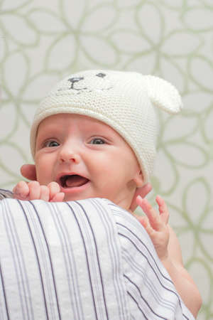 baby in a hat holding her head