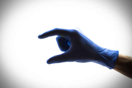 Hand doctor in blue gloves on a white backgroundの写真素材